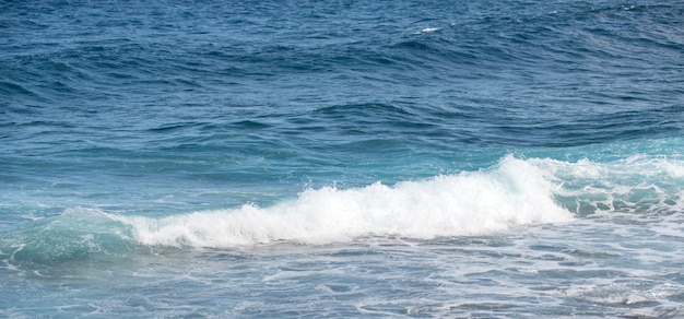 水しぶきと波のある穏やかな海の水面の質感。抽象的な自然の背景。アクア海の水面の背景。