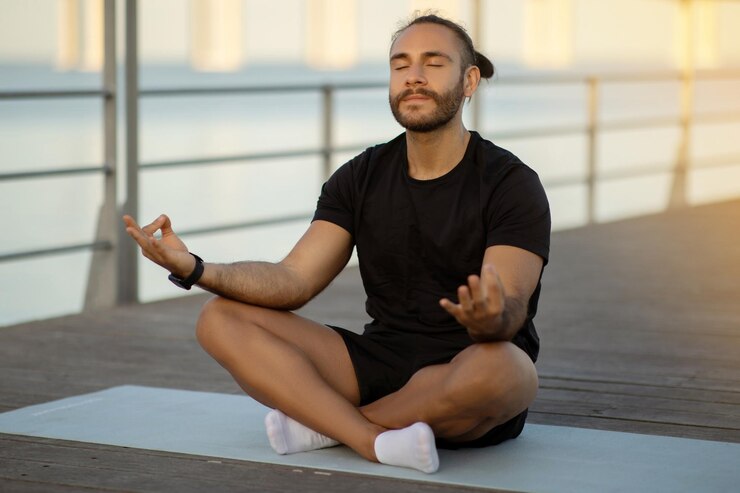 Photo calm sporty guy practicing yoga in lotus position meditating outside