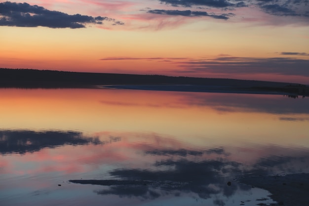 Calm sunset with cloud reflections in the lake.