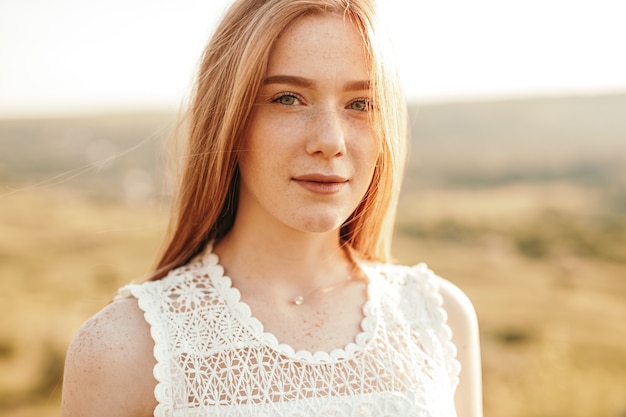 Calm teenager with freckles at sunset