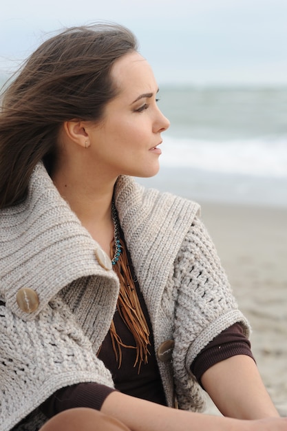 Calm woman profile portrait sitting alone on a sea beach