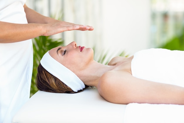 Calm woman receiving reiki treatment