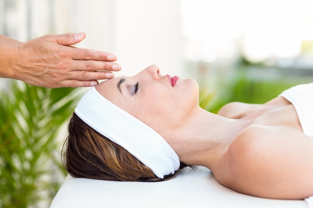 Calm woman receiving reiki treatment