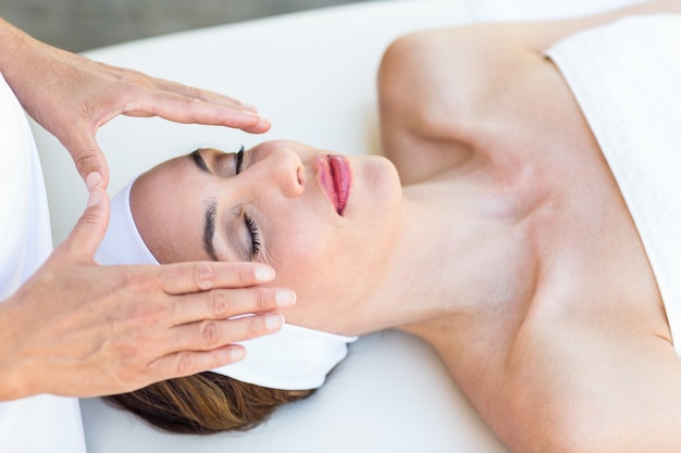 Calm woman receiving reiki treatment