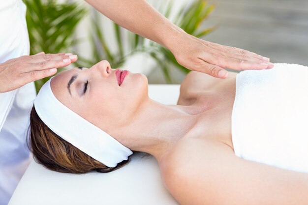 Calm woman receiving reiki treatment