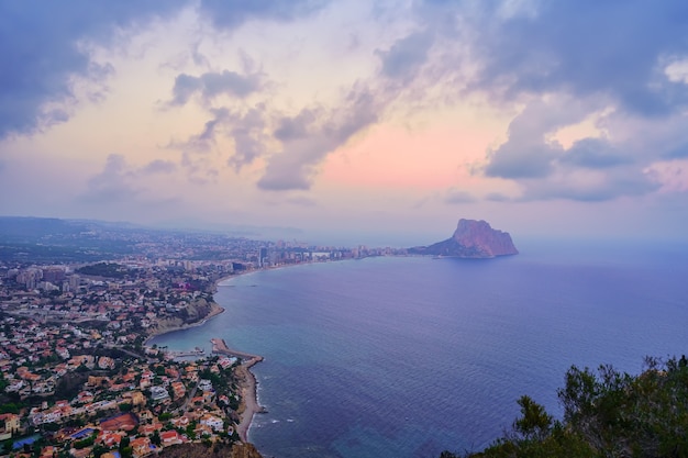 일몰에 흐린 날 바다 한가운데 바위가 있는 Calpe Alicante 베이.