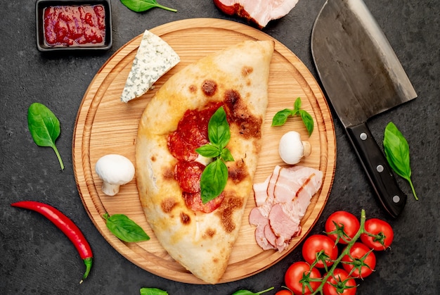 Calzone met ham en champignons op een stenen ondergrond