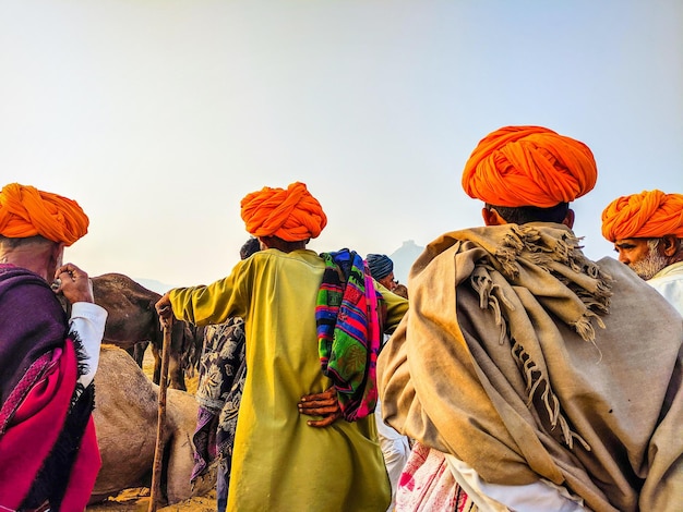 Photo camel traders negotiating on the prices of their camels pushkar rajasthan india