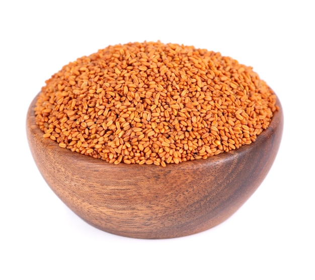 Camelina sativa seeds in wooden bowl isolated on white background Seeds of camelina or false flax Raw material for camelina oil