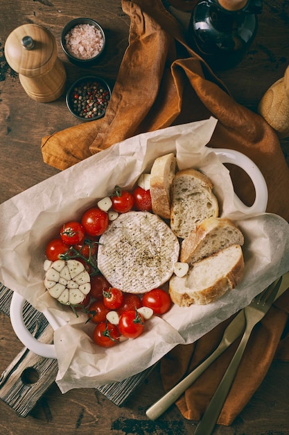 Camembert cheese baked with cherry tomatoes and baguette