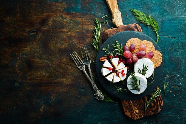 Photo camembert cheese brie cheese with cranberries and snacks rustic style free copy space