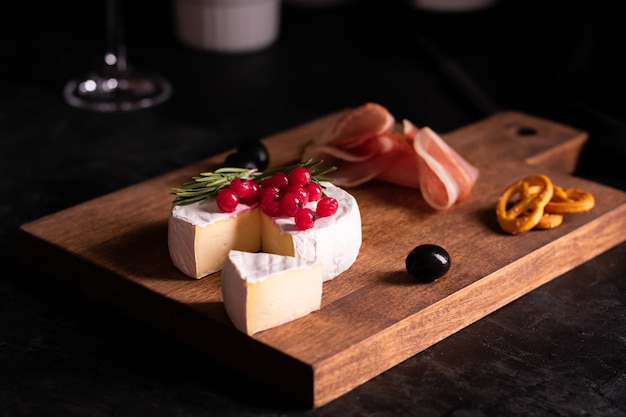 Camembert cheese decorated with berries and rosemary