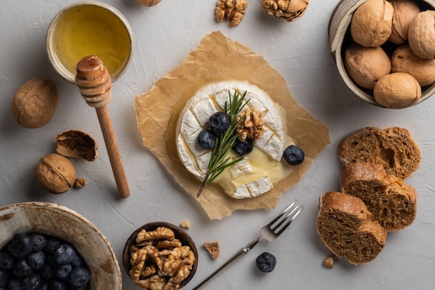 Camembert cheese on paper blueberrys nuts honey sandwicheson on grey background Italian French