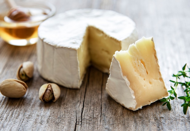 Camembert cheese, and snacks on old wooden table