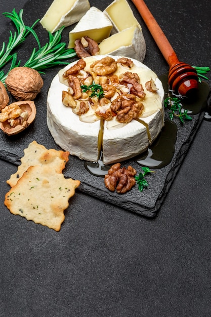 Camembert cheese and walnuts on stone serving board