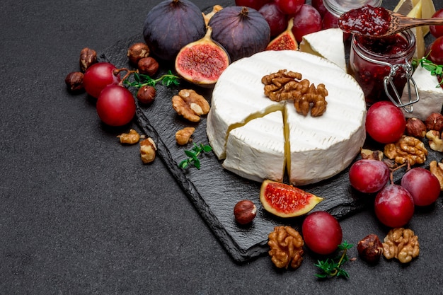 Camembert cheese and walnuts on stone serving board