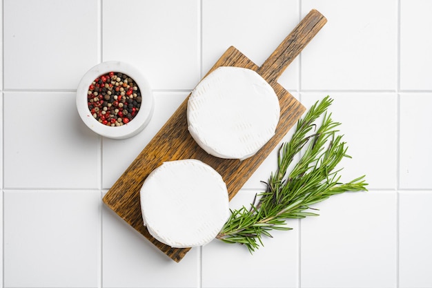 Camembert cheese on white ceramic squared tile table background top view flat lay