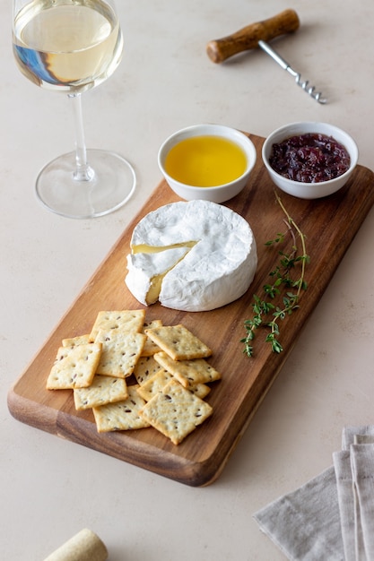 Formaggio camembert con cracker, miele e marmellata. spuntino di vino.