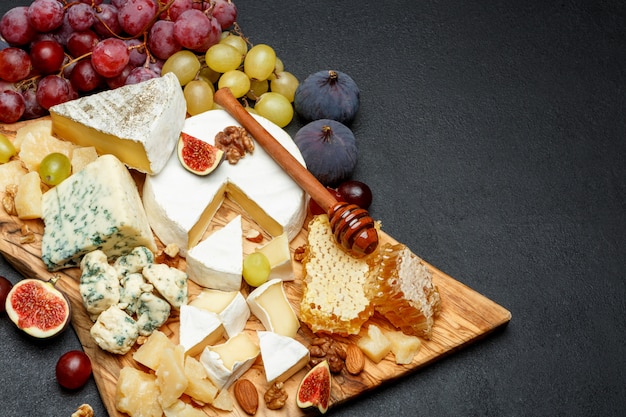 Camembert cheese with honey, figs, walnuts on wooden board