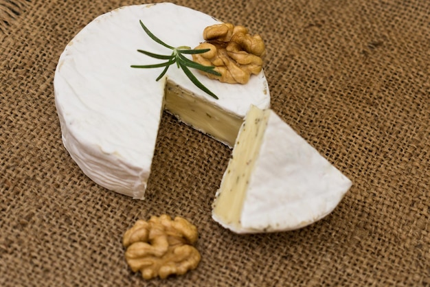 Camembert cheese with walnuts and rosemary. Close-up.