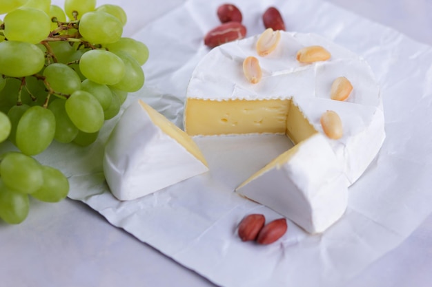 Camembert Franse roomkaas gemaakt van koemelk geserveerd met honing en fruit Voedsel voor een gezonde en smakelijke snack op een witte achtergrond Close-up