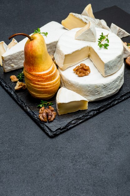 Foto camembert kaas en peer op stenen bord