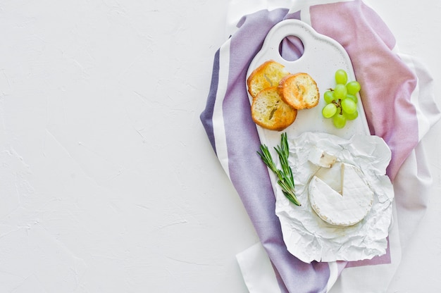 Camembert kaas met noten op een witte snijplank