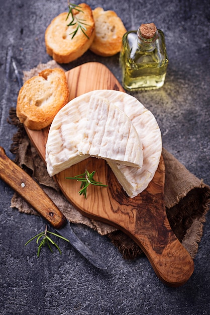 Camembert kaas met rozemarijn op een houten bord