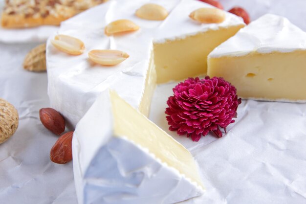 Camembert nuts berries honey a glass of milk and a cookie with seeds on a light background Breakfast food Closeup