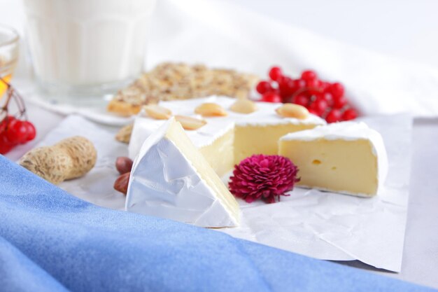 Camembert nuts berries honey a glass of milk and a cookie with seeds on a light background Breakfast food Closeup