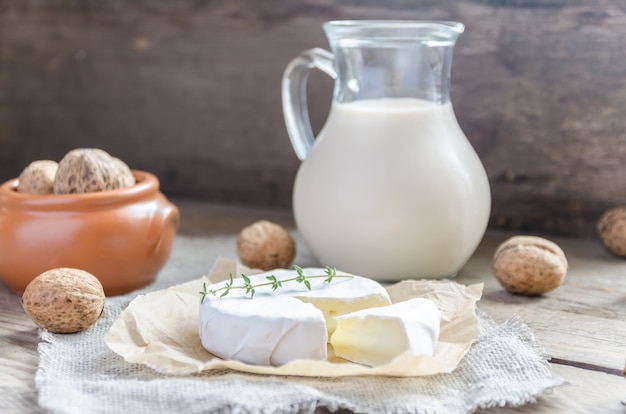 Foto camembert con brocca di latte e noci intere