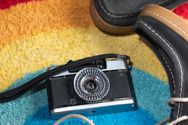 Foto una macchina fotografica su un tappeto con sopra un paio di scarpe