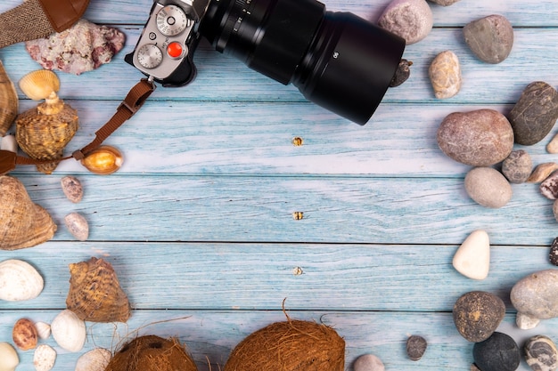 Camera,coconuts and shells on a blue wooden background.Marine theme