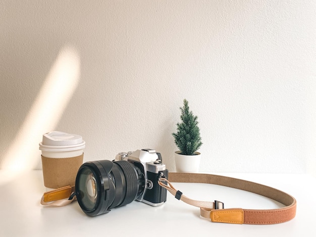 Camera and coffee cup on table in cafe background style minimal