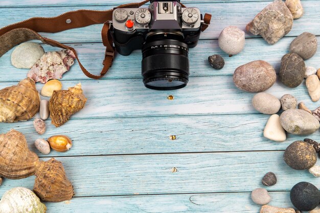 Camera en schelpen op een blauwe houten achtergrond. Marien thema