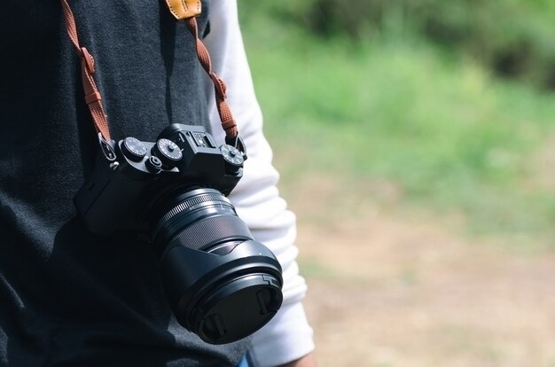 Macchina fotografica che appende con la cinghia della macchina fotografica al fotografo.