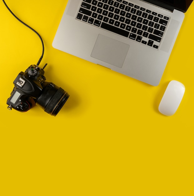 Camera and laptop isolated on yellow