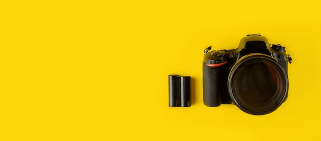 Camera and lens isolated on yellow