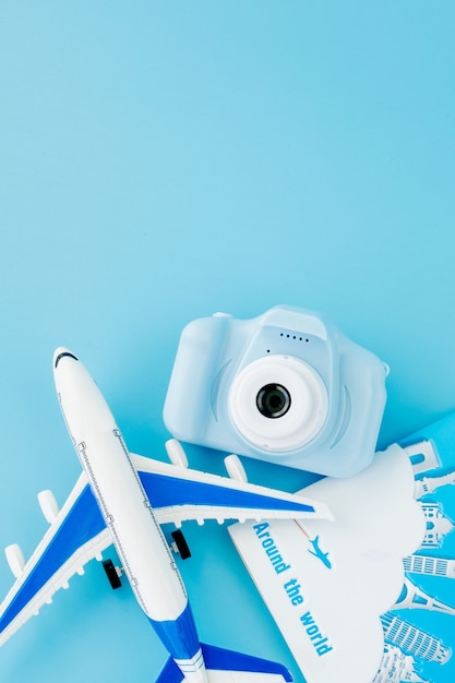 Camera, passport and airplane on light blue background.Summer or vacation concept. Copy space.