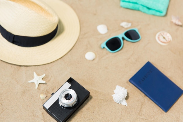 카메라, 여권, 선글라스, 해변 모래에 모자