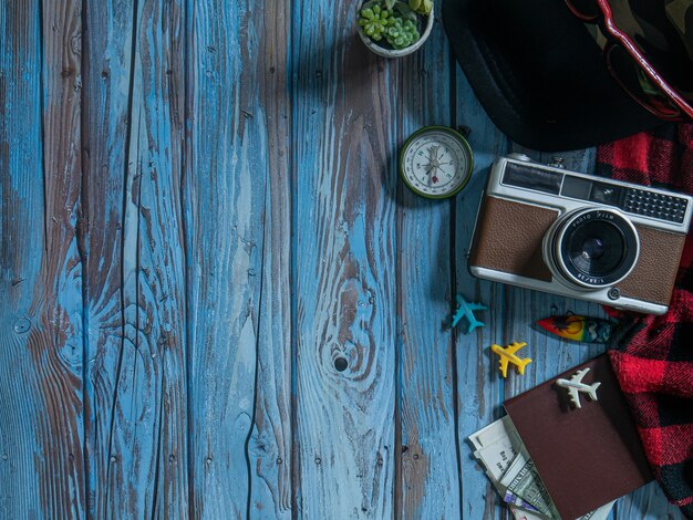 The camera and passport on wood table for travel concept.