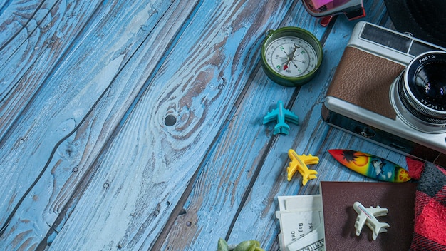 The camera and passport on wood table for travel concept.