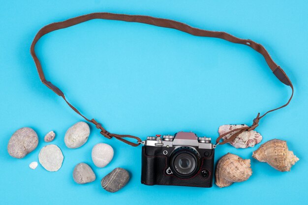 Camera, rocks and seashells in beach concept