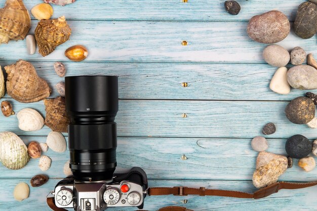 Camera, rocks and seashells in beach concept