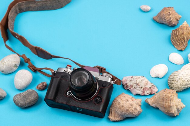 Camera, rotsen en schelpen in strandconcept