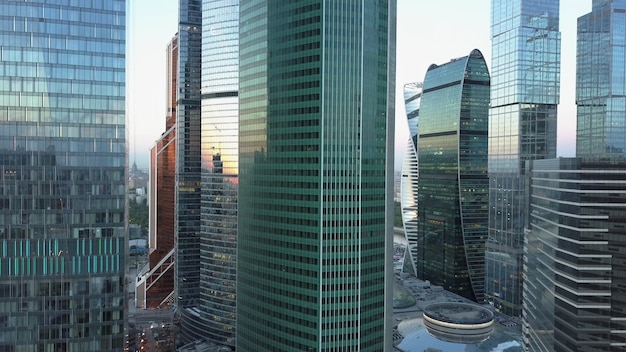 Camera stijgt onder de hoogbouw kantoorgebouwen in het zakencentrum van de stad. Moderne wolkenkrabbers bij zonsondergang