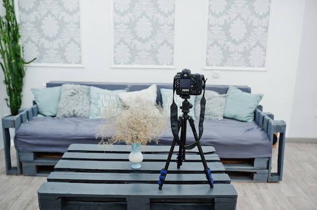 Camera on a tripod in cozy bedroom interior.