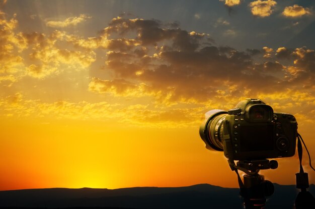 Camera on tripod and photography view camera with blurred focus\
landscape of sunset sunrise sun light sky cloud