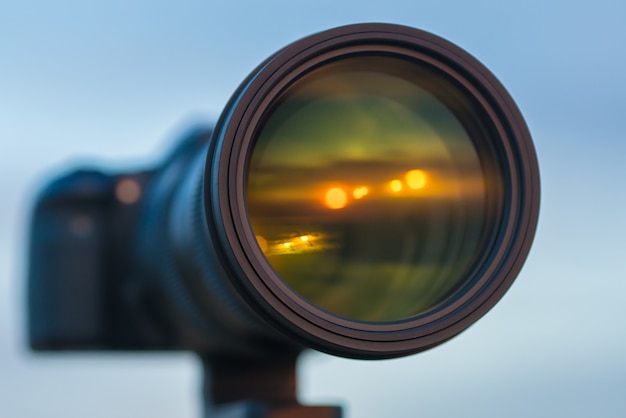 The camera with a big lens on the background of the sky