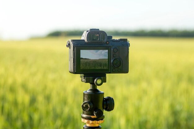 Una fotocamera con un obiettivo su un treppiede pronta per scattare foto o video in natura fotografare e filmi...